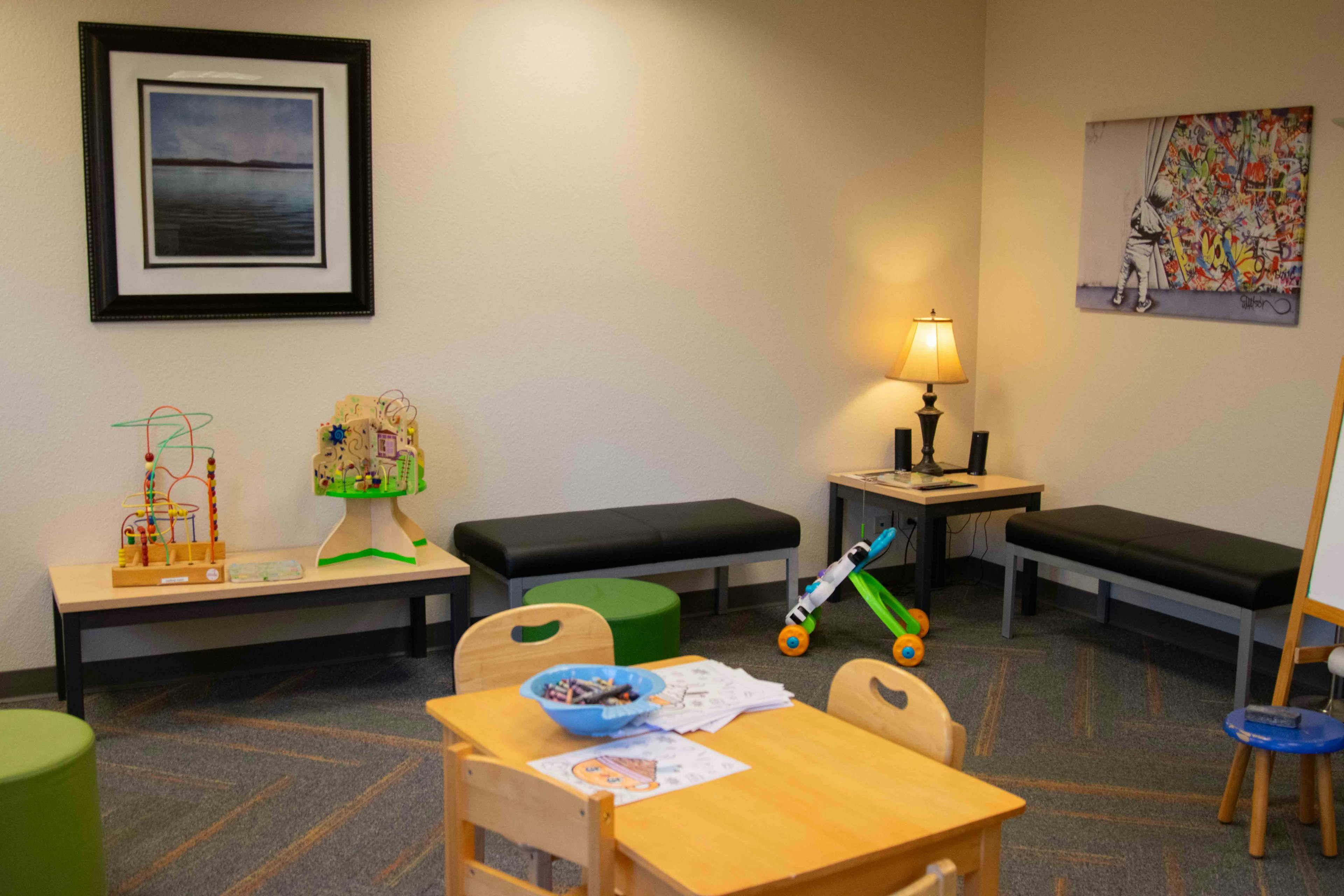 Inside lobby of Norton. Playroom with kids' games and benches along the wall.