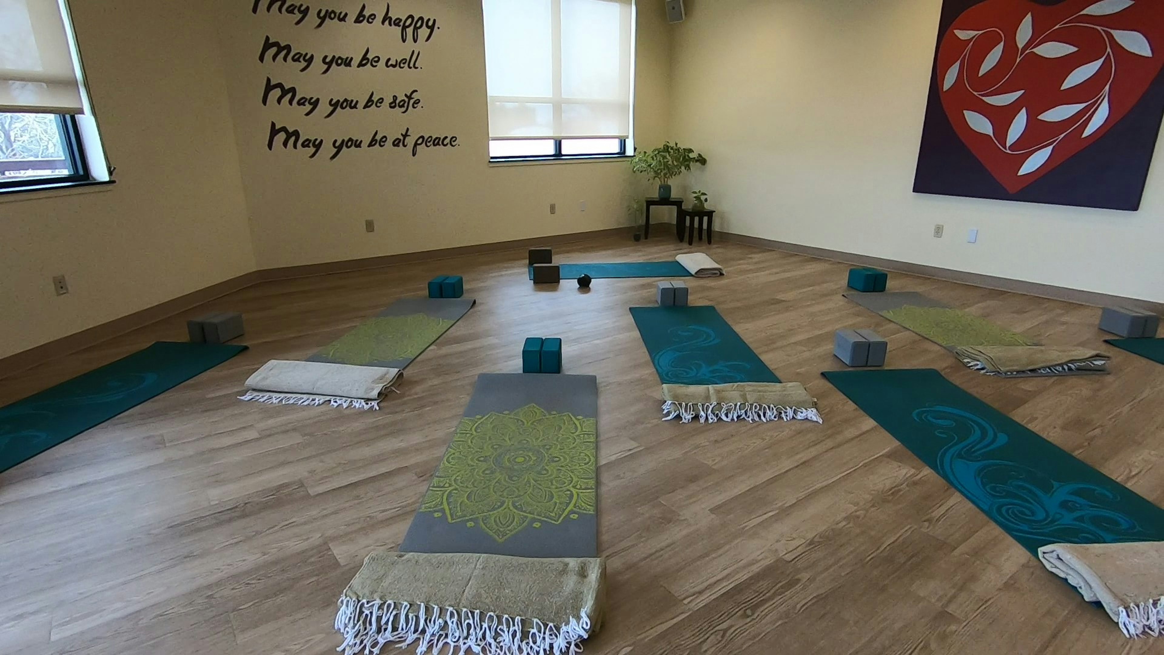 Yoga studio located on the second floor of Dixon. Yoga mats, blankets, and blocks set up. Writing on the wall that reads: May you be happy. May you be well. May you be safe. May you be at peace.