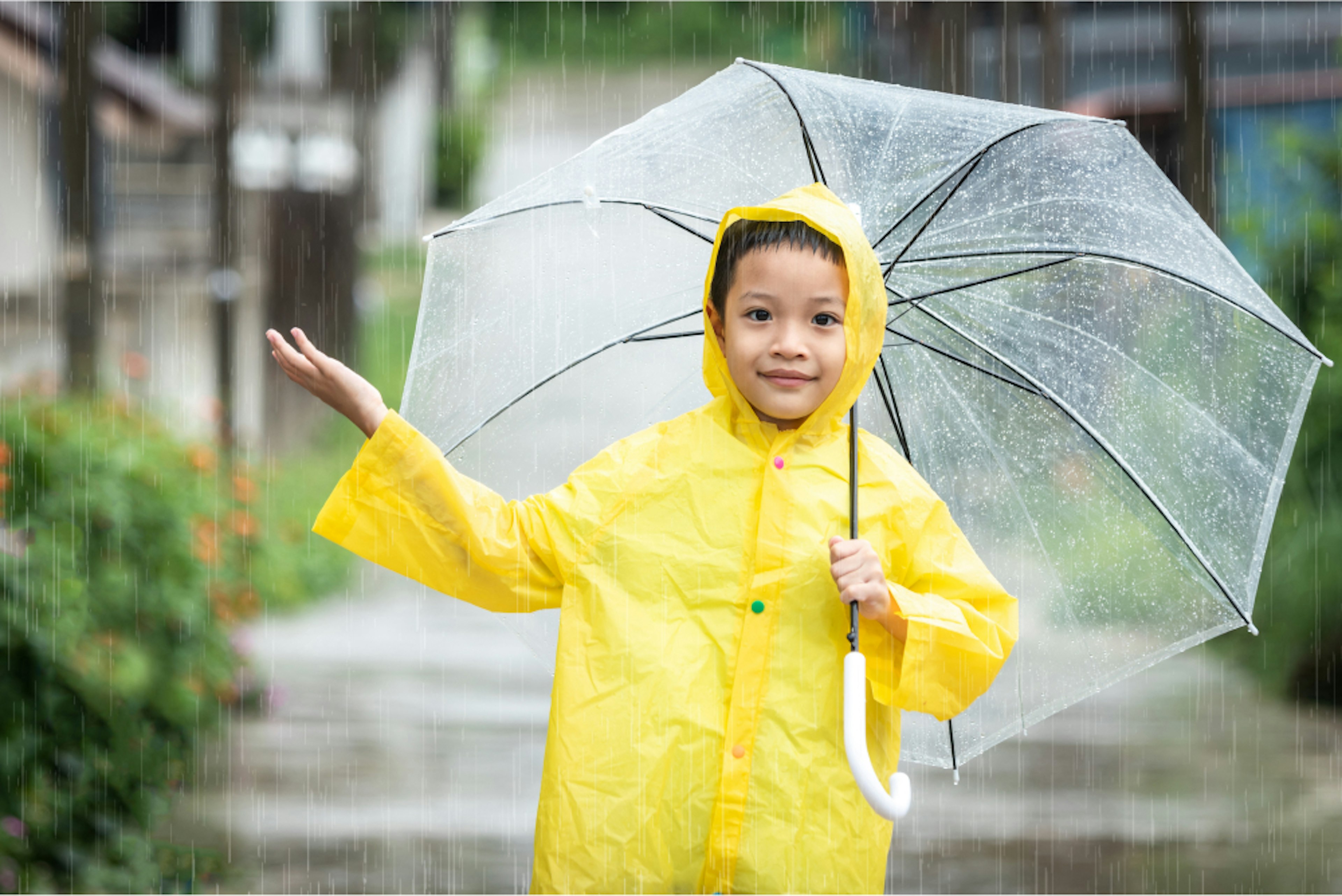 Kid Connects Tile: Kid in yellow raincoat holding a clear umbrella in the rain.