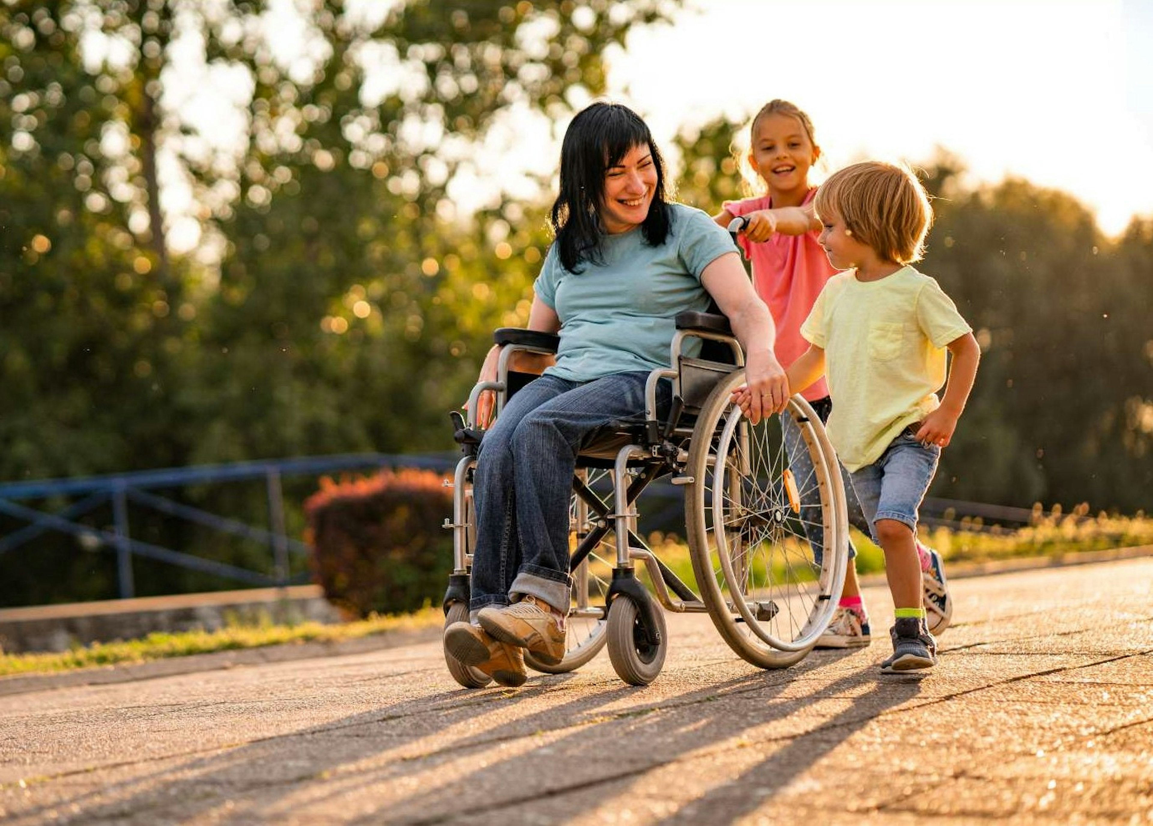 Woman in wheelchair traveling down path with kids.