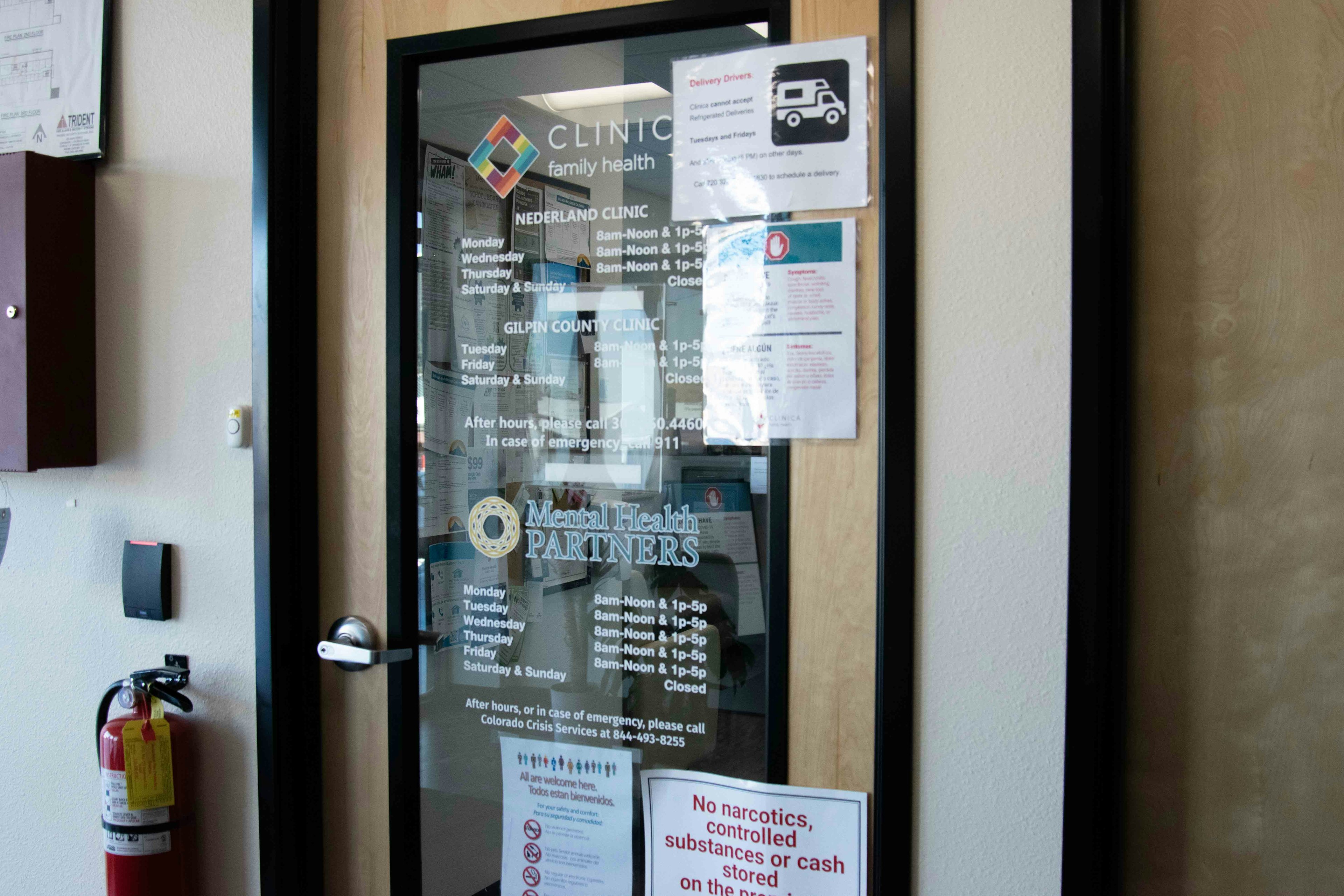 Front door of MHP and Clinica offices. Glass door with logos and schedules written in white text.